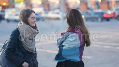 两个年轻漂亮的学生，时髦的女孩，在汽车附近的城市街道上谈笑风生，稳重的凸轮，缓慢的